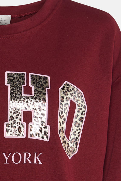 Sweat-shirt rouge de Terra di Siena avec imprimé léopard sur les lettres et l’inscription « York ».
