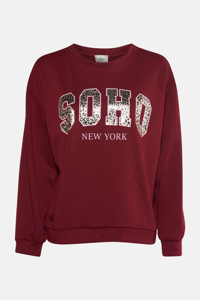 Sweat rouge col rond par Terra di Siena avec inscription léopard "Soho New York".
