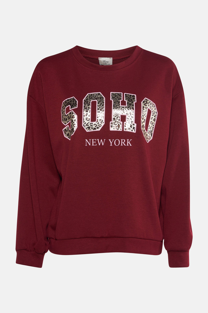Sweat rouge col rond par Terra di Siena avec inscription léopard "Soho New York".
