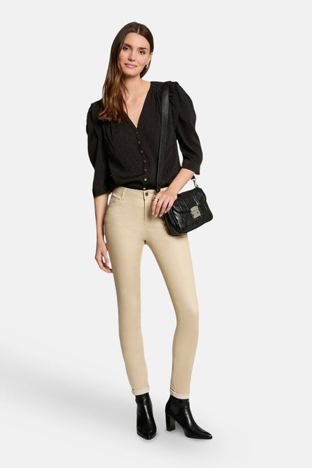 Chemisier noir à manches longues de Morgan de Toi, porté avec un pantalon beige, un sac à bandoulière et des bottines noires.