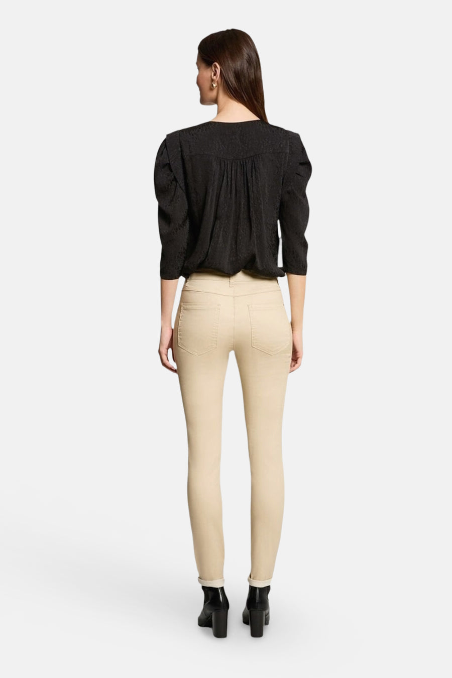 Chemisier noir à manches longues de Morgan de Toi, avec un motif texturé, porté avec un jean beige et des bottines noires.