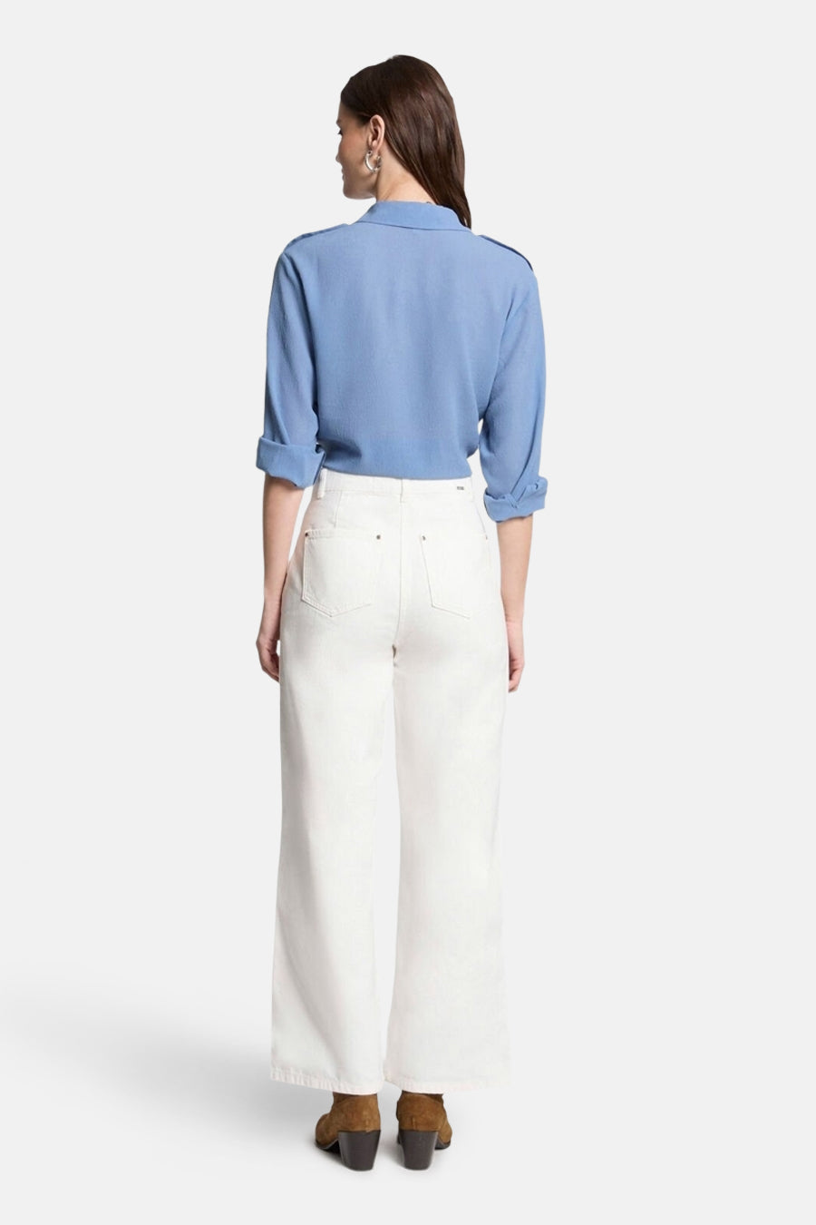 Blauwe blouse met lange mouwen van Morgan de Toi met schoudervullingen, gedragen met een witte jeans en bruine enkellaarsjes.