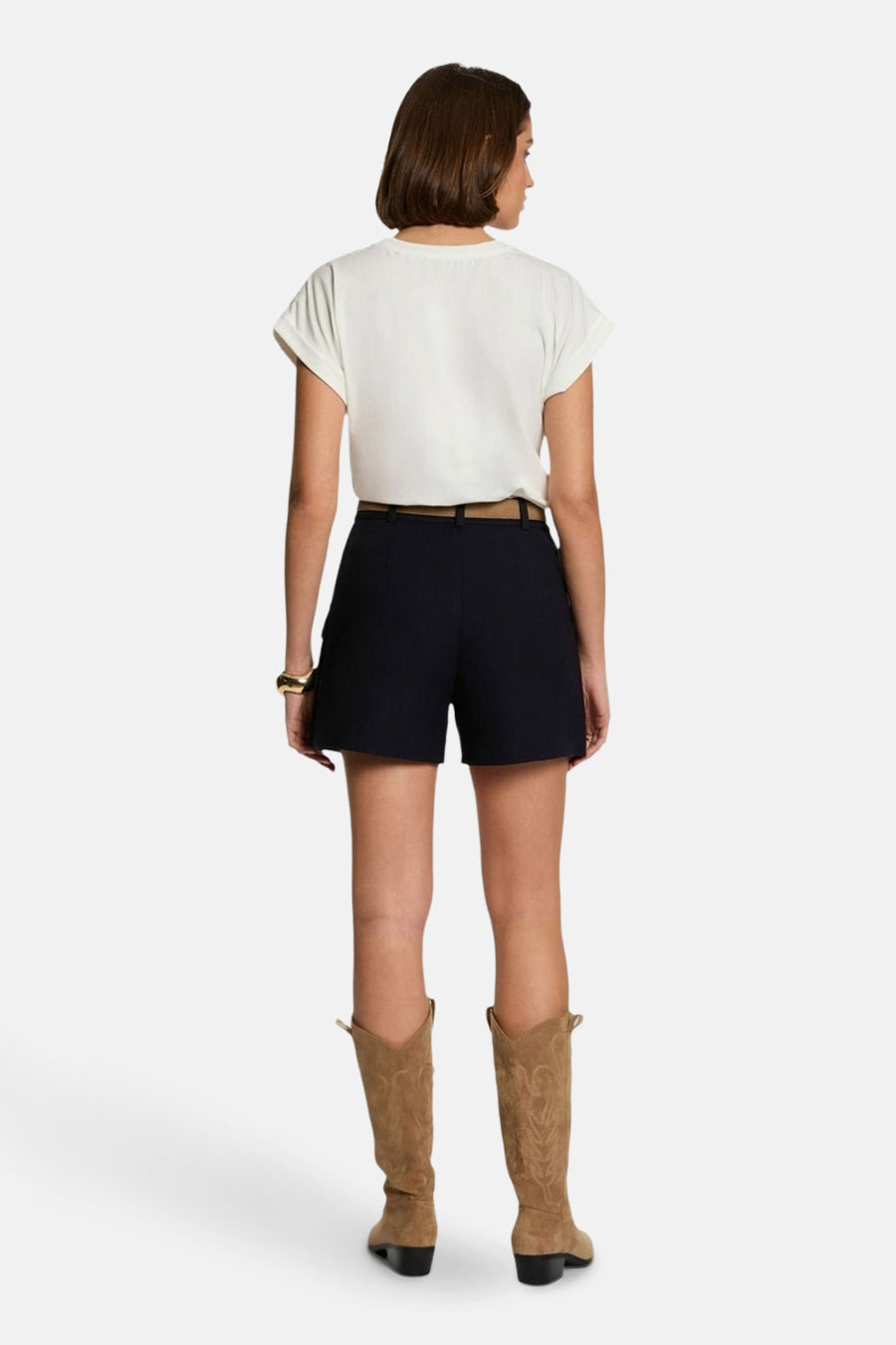 T-shirt blanc à manches courtes de Morgan de Toi, porté avec un short noir et des bottes en daim.