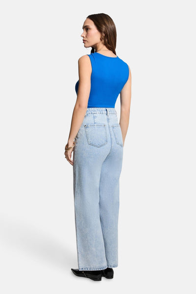 Blauw mouwloos topje van Morgan de Toi, gedragen met een high-waisted jeans en zwarte schoenen.
