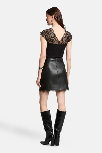 Top noir sans manches de Morgan de Toi avec dentelle florale, porté avec une jupe en cuir et des bottes noires.