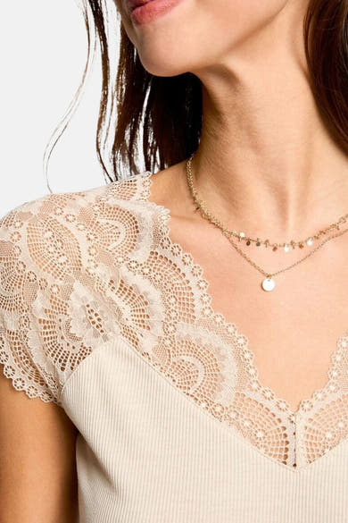Top sans manches beige de Morgan de Toi orné de dentelle florale à l'encolure et épaules, avec double collier doré.
