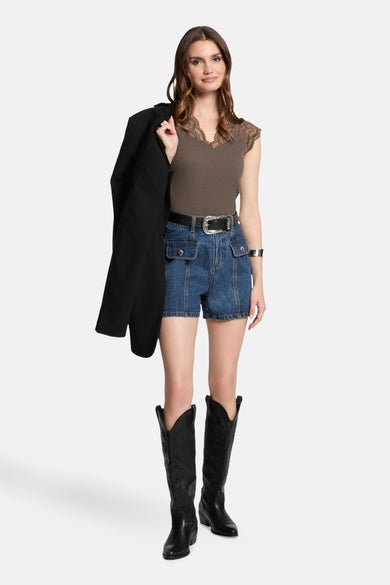 Top sans manches kaki de Morgan de Toi avec bordure en dentelle, porté avec un short en jean et des bottes noires.
