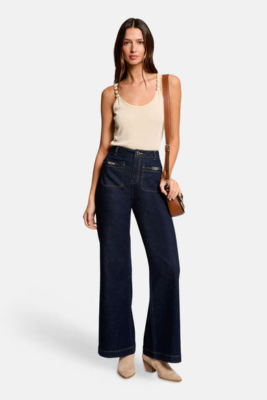 Beige top van Morgan de Toi met decoratieve bandjes, gedragen met een high-waisted flared jeans en suède enkellaarsjes.