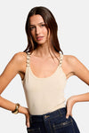 Beige top van Morgan de Toi met bandjes versierd met gouden ringen, gedragen met een low-rise jeans.