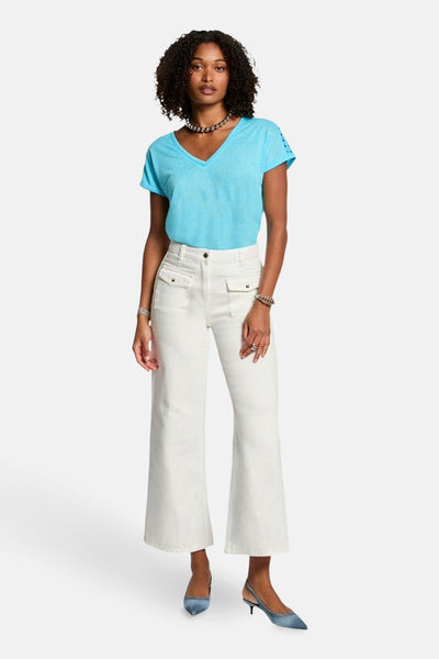 T-shirt bleu à manches courtes de Morgan de Toi, porté avec un pantalon taille haute et des escarpins.