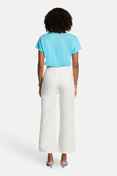 T-shirt bleu à manches courtes de Morgan de Toi, porté avec un jean blanc taille haute.