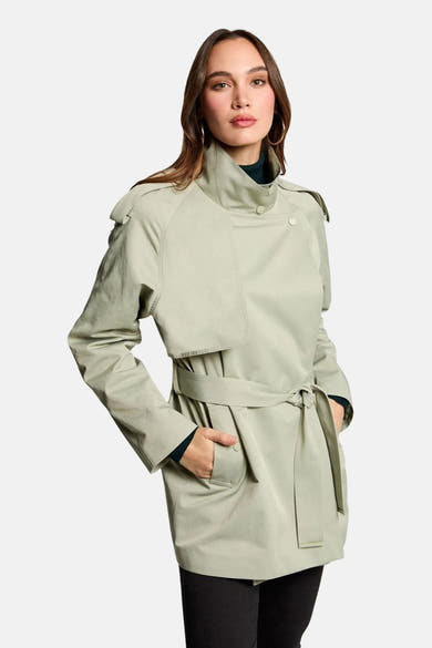 Veste vert clair de Morgan de Toi, avec ceinture et col montant, portée sur un pull à col roulé foncé.
