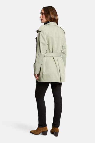 Veste vert pâle de Morgan de Toi, avec ceinture et détails structurés, portée avec un pantalon noir et des bottines marron.