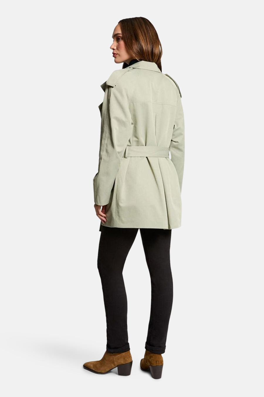 Veste vert pâle de Morgan de Toi, avec ceinture et détails structurés, portée avec un pantalon noir et des bottines marron.