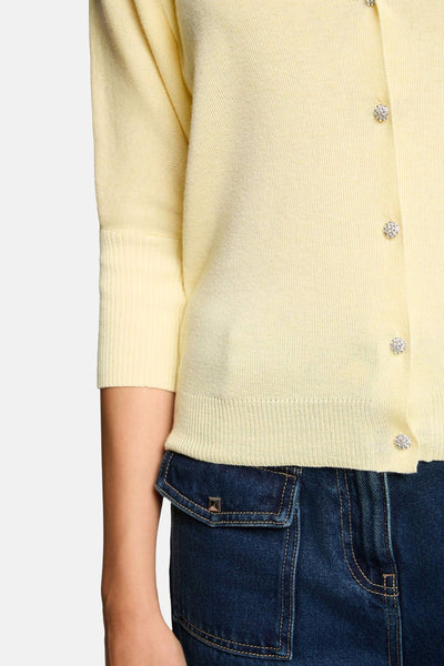 Cardigan jaune en maille fine de Morgan de Toi, manches trois-quarts côtelées et boutons bijoux brillants.