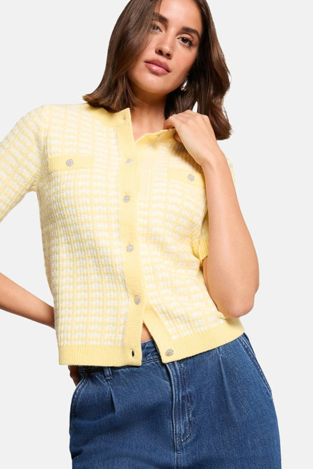 Cardigan jaune Morgan de Toi à carreaux, avec des boutons décoratifs et porté avec un jean taille haute.
