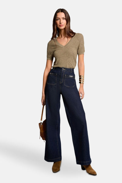 Kaki V-hals trui van Morgan de Toi met textuurpatroon, gedragen met een wijde jeans en bruine enkellaarsjes.