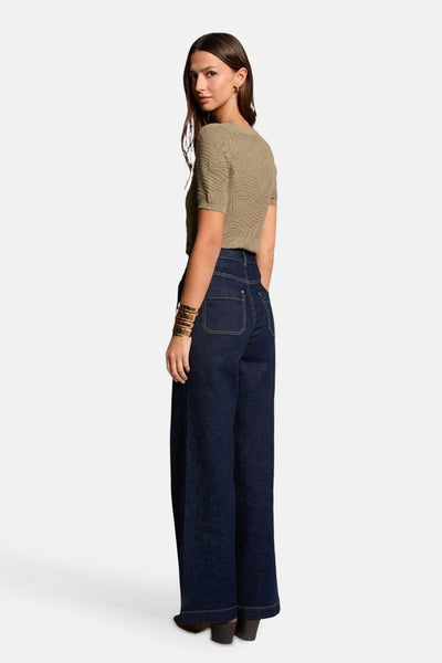 Kaki V-hals trui van Morgan de Toi, met textuurpatroon, gedragen met een wijde high-waist jeans.