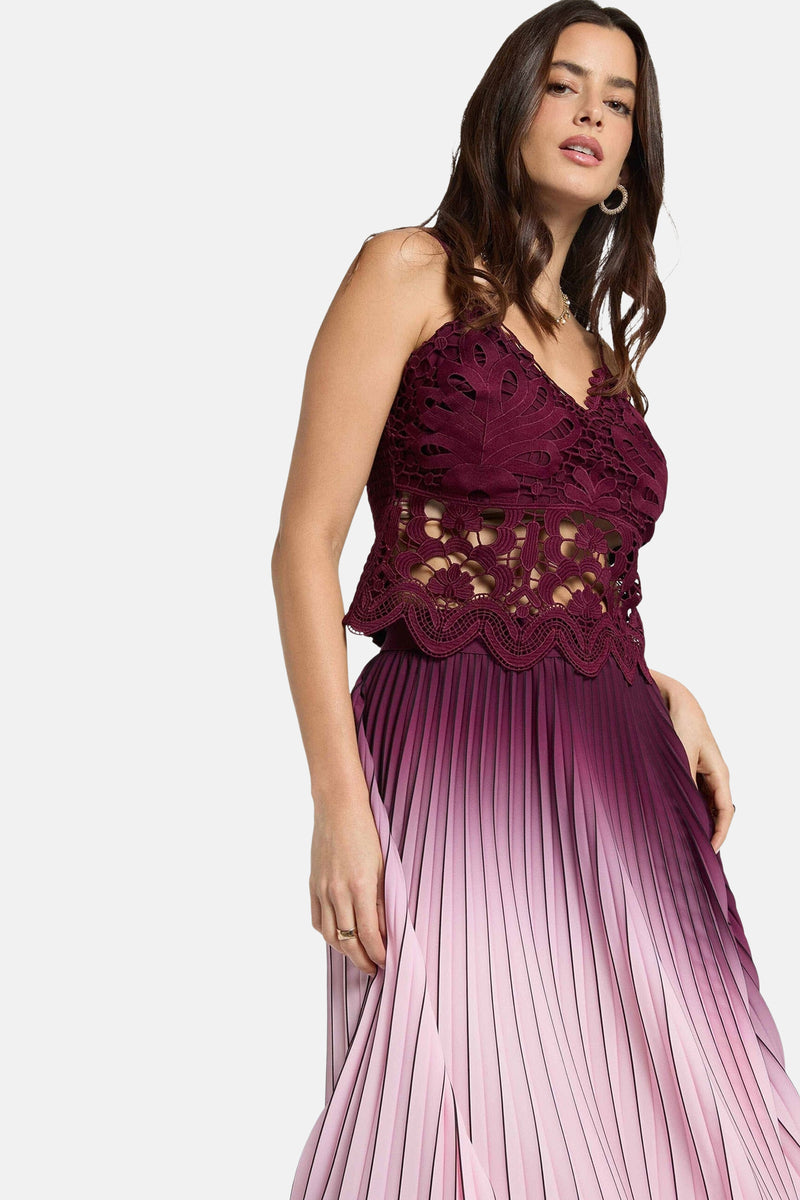 Mouwloos bordeauxrood topje van Morgan de Toi, met een smocktextuur en een geplooide, roze ombré rok.