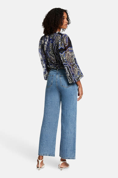 Chemisier bleu à manches longues de Morgan de Toi, motif cachemire, porté avec un jean taille haute.