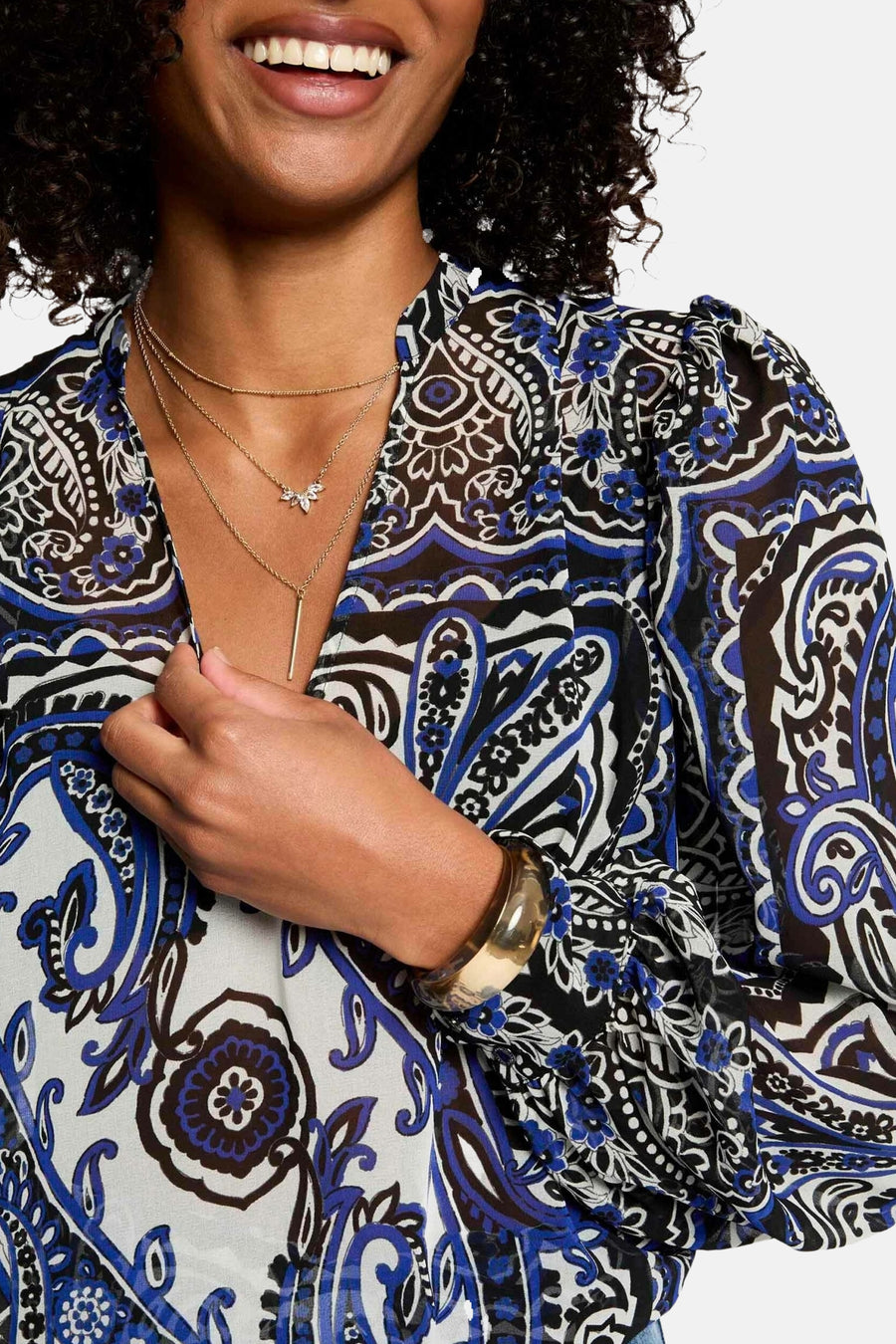 Blauwe blouse met lange mouwen van Morgan de Toi, met kasjmierprint en versierd met gouden sieraden.