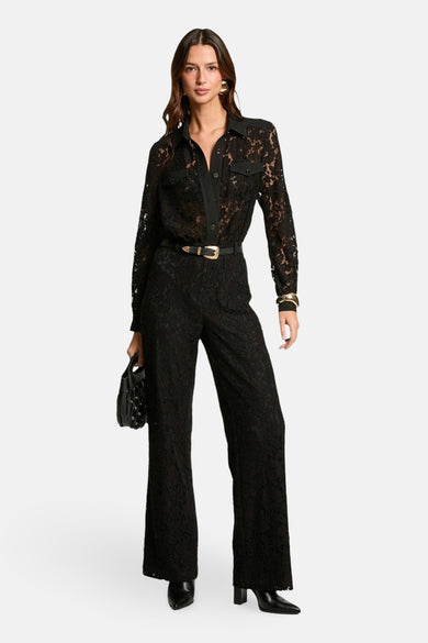 Zwarte jumpsuit van Morgan de Toi met kant, gouden riem, oorbellen en armband.