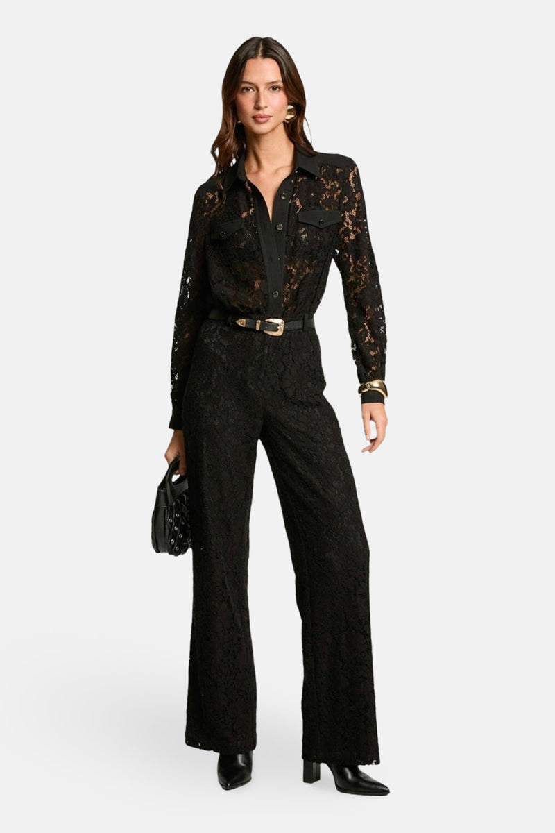 Zwarte jumpsuit van Morgan de Toi met kant, gouden riem, oorbellen en armband.
