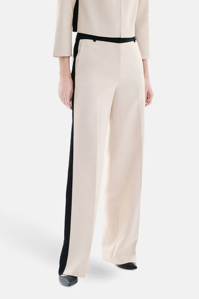 Beige kostuumbroek van CAROLL, met een contrasterende zwarte bies aan de zijkant, gedragen met een bijpassend jasje.