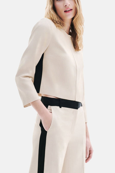 Beige kostuumbroek van CAROLL, met een zwarte bies aan de zijkant en een zwarte riem.