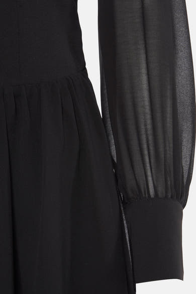 Zwarte jurk met lange mouwen van Morgan de Toi, met doorschijnende mouwen en geplooide details.