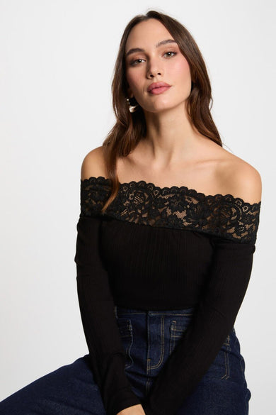 T-shirt noir à manches longues de Morgan de Toi, avec bordure en dentelle et porté avec un jean.
