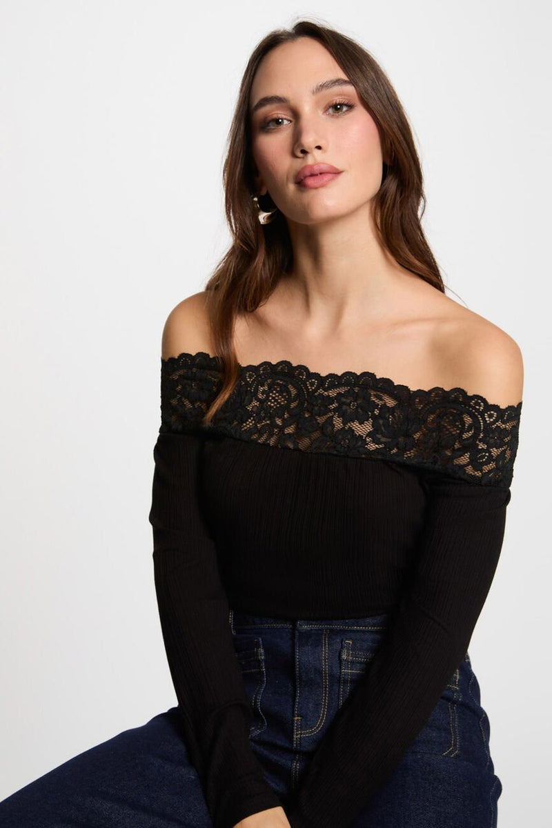 T-shirt noir à manches longues de Morgan de Toi, avec bordure en dentelle et porté avec un jean.
