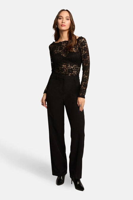 T-shirt à manches longues noir de Morgan de Toi en dentelle florale, porté avec un pantalon noir taille haute.