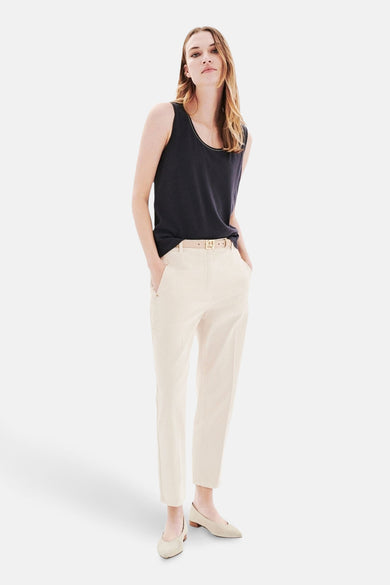 Top sans manches gris CAROLL, porté avec un pantalon taille haute écru et des chaussures plates assorties.
