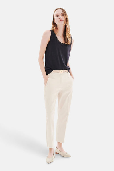 Top sans manches gris CAROLL, porté avec un pantalon taille haute écru et des chaussures plates assorties.