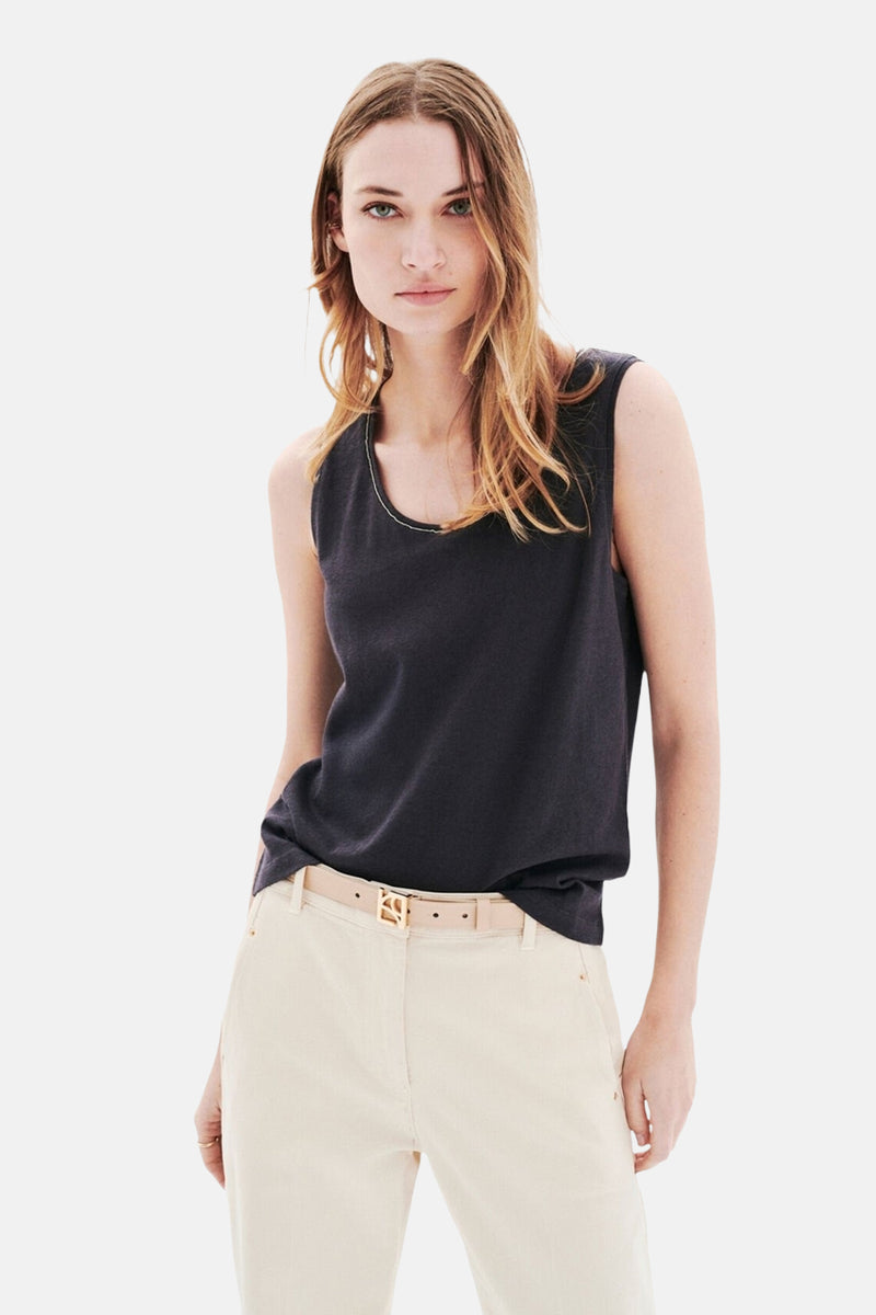 Top sans manches gris de CAROLL, porté avec un pantalon taille haute et une ceinture beige.
