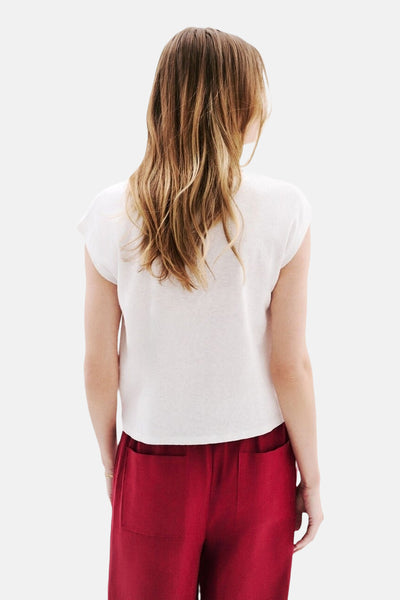 T-shirt à manches courtes blanc de CAROLL, porté avec un pantalon rouge taille haute, vue de dos.