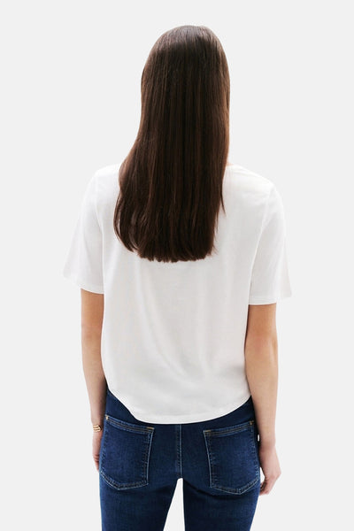 T-shirt blanc à manches courtes de Caroll, porté avec un jean bleu, vue de dos.
