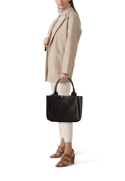 Sac à bandoulière noir de Morgan de Toi avec motif léopard à l'intérieur, porté avec manteau beige et chaussures marron.
