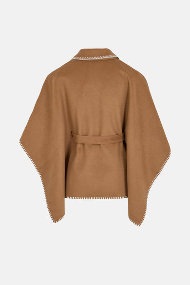 Cognac poncho van Morgan de Toi, met ceintuur en witte gegolfde details.