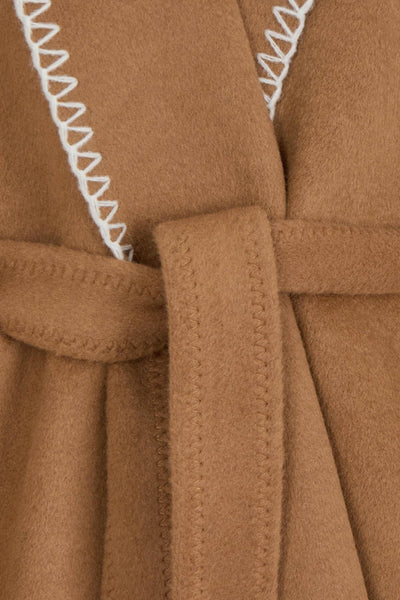 Cognac poncho van Morgan de Toi met witte geschulpte afwerkingen en een bijpassende ceintuur.