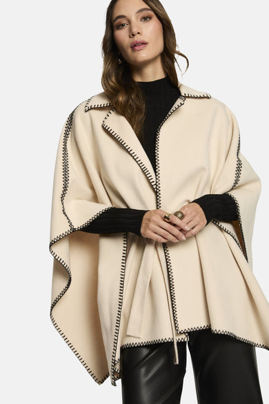 Poncho van Morgan van Toi in ecru met zwarte pelsrand en knopenband.