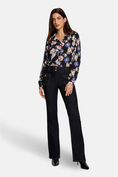 Multikleuren blouse met lange mouwen van Morgan de Toi met een bloemenpatroon, gedragen met een spijkerbroek en zwarte enkellaarsjes.