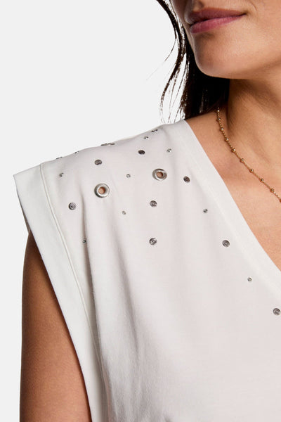 Wit T-shirt met korte mouwen van Morgan de Toi, versierd met zilveren studs en oogjes, met een gouden kralenketting.