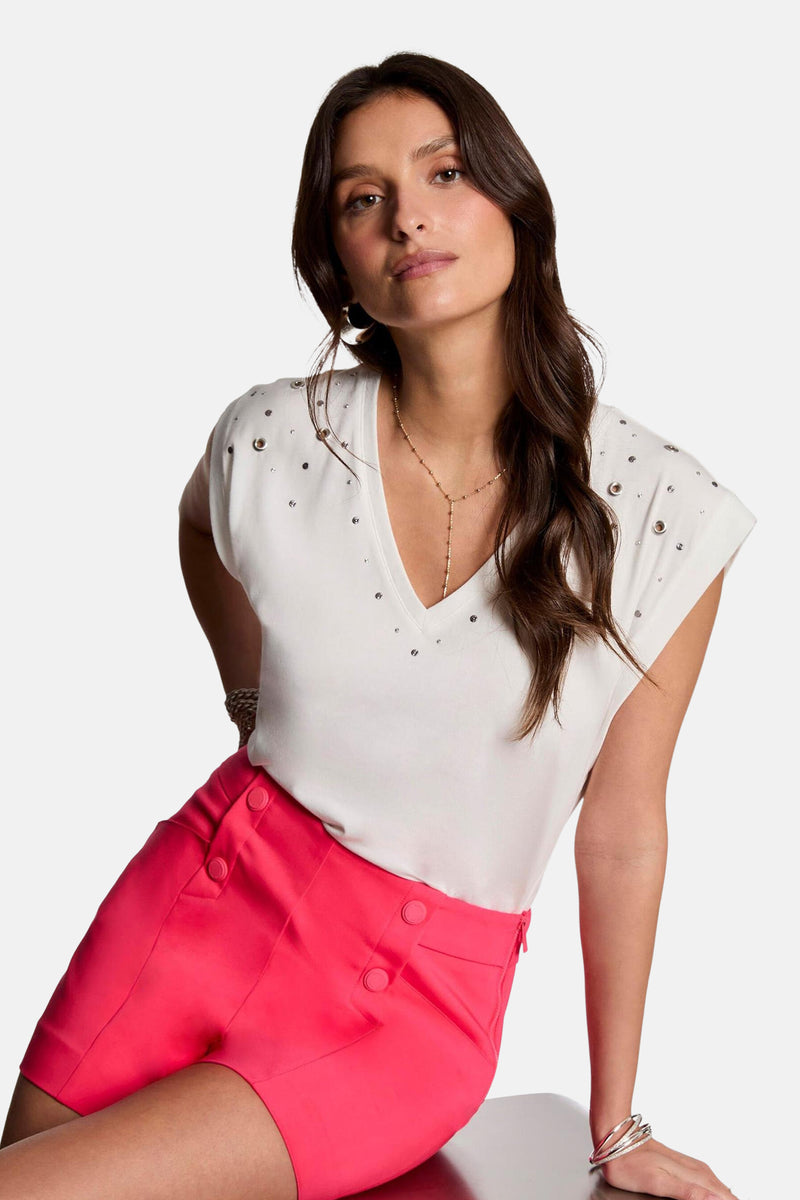 Effortloos wit T-shirt met korte mouwen van Morgan de Toi, versierd met metalen details, gedragen met een roze short.