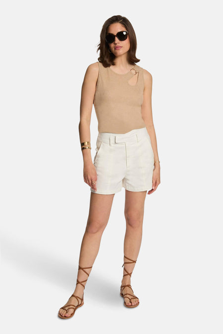 Beige T-shirt van Morgan de Toi met ringuitsparing, gedragen met een witte korte broek en sandalen met bandjes.