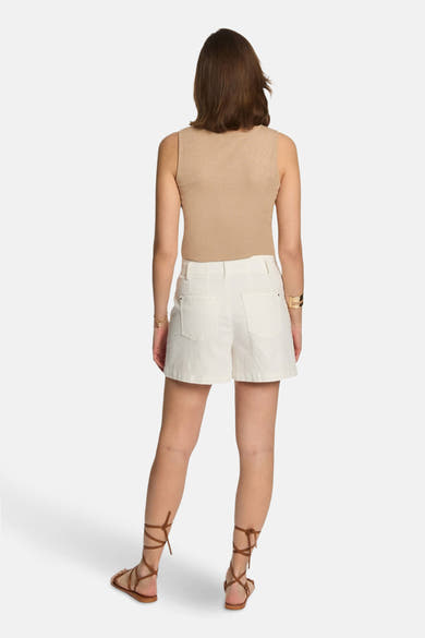 Beige T-shirt van Morgan de Toi, gedragen met een witte korte broek en sandaaltjes met veters.