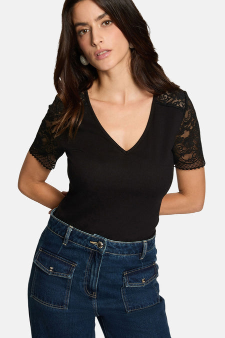 Black ribbed V-neck T-shirt with lace sleeves, worn with dark blue jeans, front view