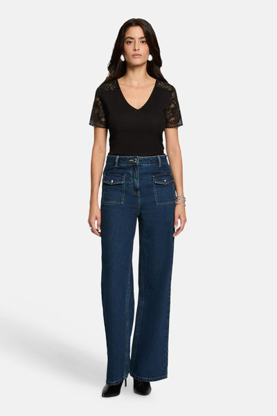 Black short-sleeve V-neck T-shirt with lace sleeves, worn with high-waisted blue jeans and black heels, front view.