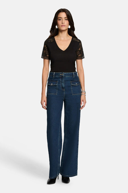 Black short-sleeve V-neck T-shirt with lace sleeves, worn with high-waisted blue jeans and black heels, front view.